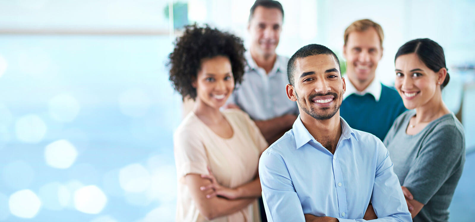 Five business professionals standing and posing in a group.